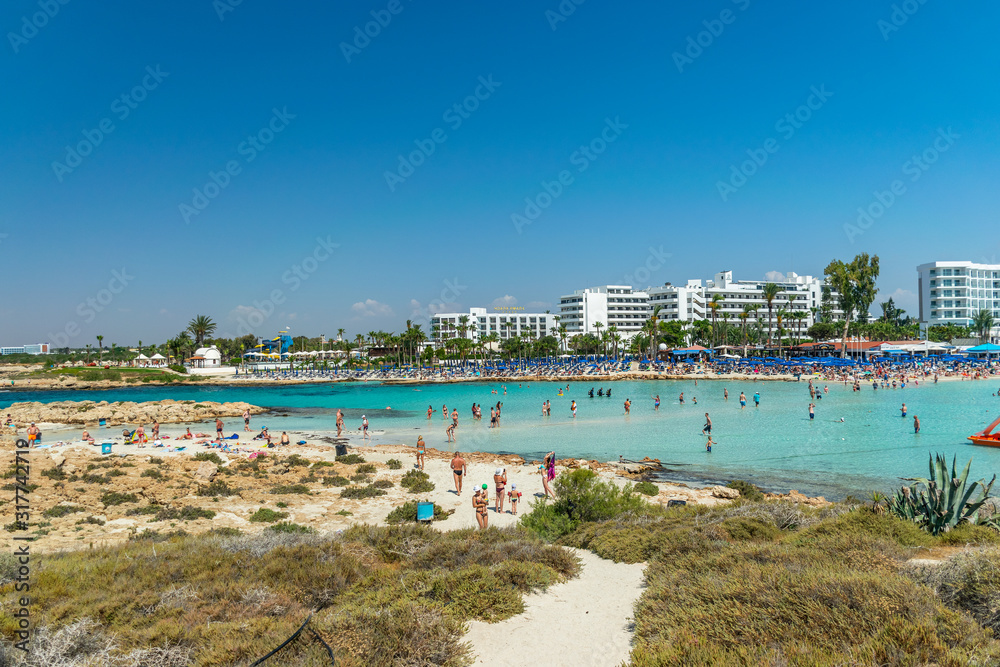 CYPRUS, NISSI BEACH - MAY 12/2018: Tourists relax and swim on one of the most popular beaches on the island.