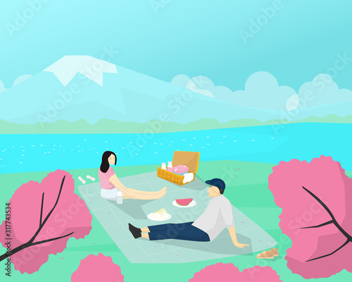 A couple lover picnic in the cherry blossom flower viewing festival in spring times.