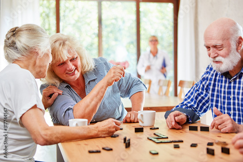 Gruppe Senioren am Tisch beim Domino Spiel