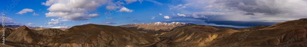 Ultra wide angle panoramic view of the mountain peaks covered with snow