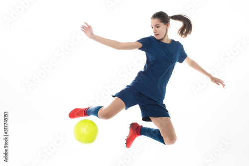 girl soccer player kicking ball isolated over white background