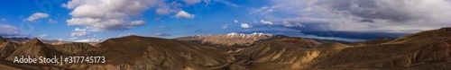 Ultra wide angle panoramic view of the mountain peaks covered with snow