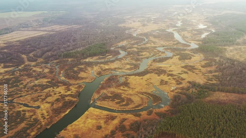 Aerial View Of Forest Woods And Partly Frozen River Landscape In Sunny Late Autunn Day. Top View Of Beautiful European Nature From High Attitude In Autumn Season. Drone View. Bird's Eye View photo