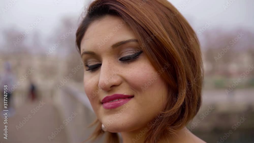 smiling lady with earrings poses on blurred background