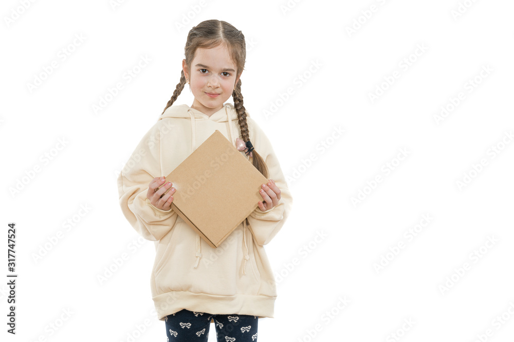 Cheerful little girl with pigtails dressed in hoodie holds cardboard box in hands and looking at the camera, isolated over white background, copyspace Cheerful little girl with pigtails dressed in hoodie holds cardboard box in hands and looking at the camera, isolated over white background, copyspace