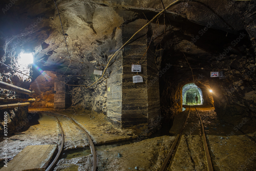 Naklejka premium Gold mine underground tunnel with rails two ways
