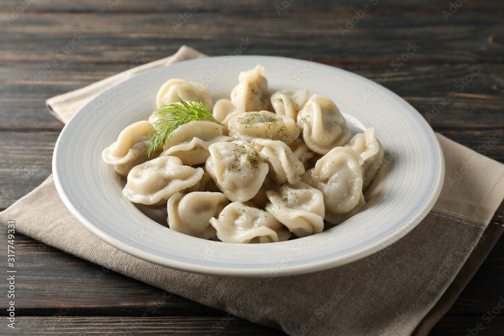 Towel and plate with dumplings on wooden background, close up Towel and plate with dumplings on wooden background, close up