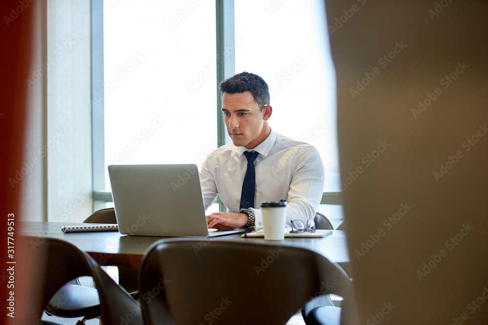 Handsome young executive putting in the hours for success
