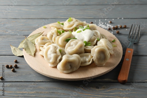Circle board with dumplings on wooden background, close up