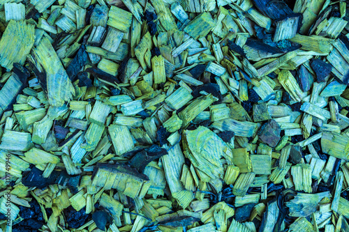 Colored in green and yellow sawdust or shavings background or texture. Heap of splinters, slivers and chips