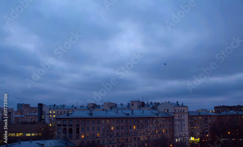 Dark cloudy sky over city buildings © Chudakov