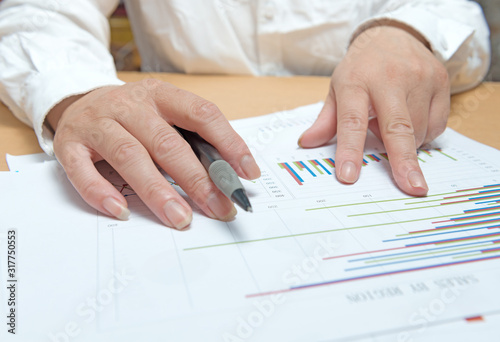 woman hand with pen and business report. Accounting