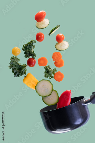 Fototapeta Naklejka Na Ścianę i Meble -  Saucepan with assorted vegetables flying in the air