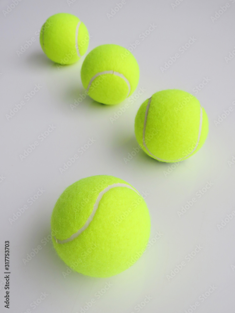 Tennis balls in a row over a white background.