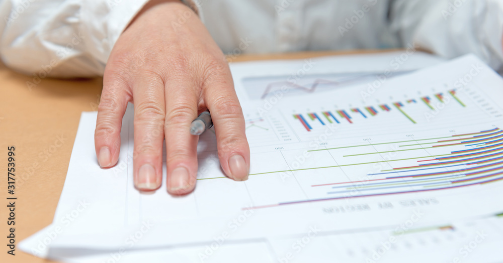 woman hand with pen and business report. Accounting woman hand with pen and business report. Accounting