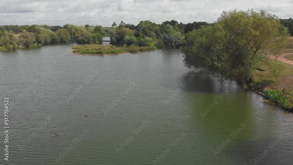 Forward moving aerial drone shot over a pond in the Ely great ouse river in England Forward moving aerial drone shot over a pond in the Ely great ouse river in England