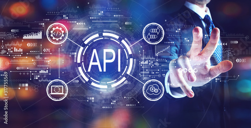 API - application programming interface concept API concept with businessman on night city background