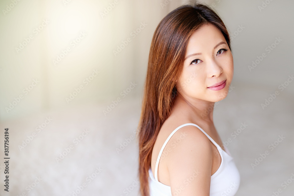 Attractive young Asian woman with perfect skin relaxing at home Attractive young Asian woman with perfect skin relaxing at home