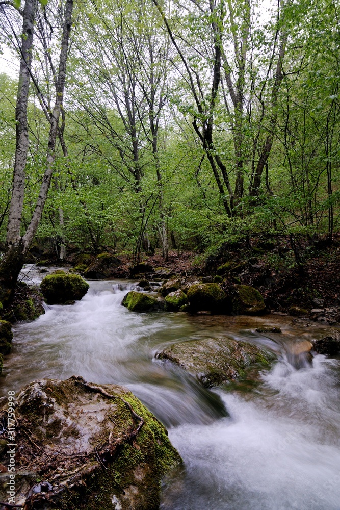 Stream with waterfall and mossy stones around Stream with waterfall and mossy stones around