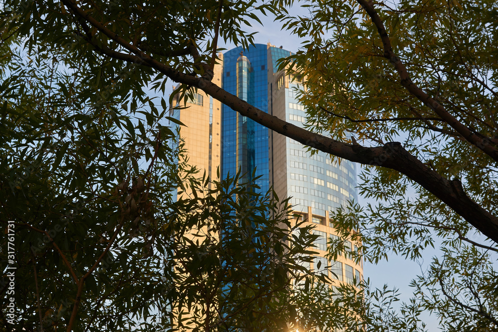 Moscow, Russia - September 12, 2019: The building of the business center Bagration. View of the building through the branches of a tree