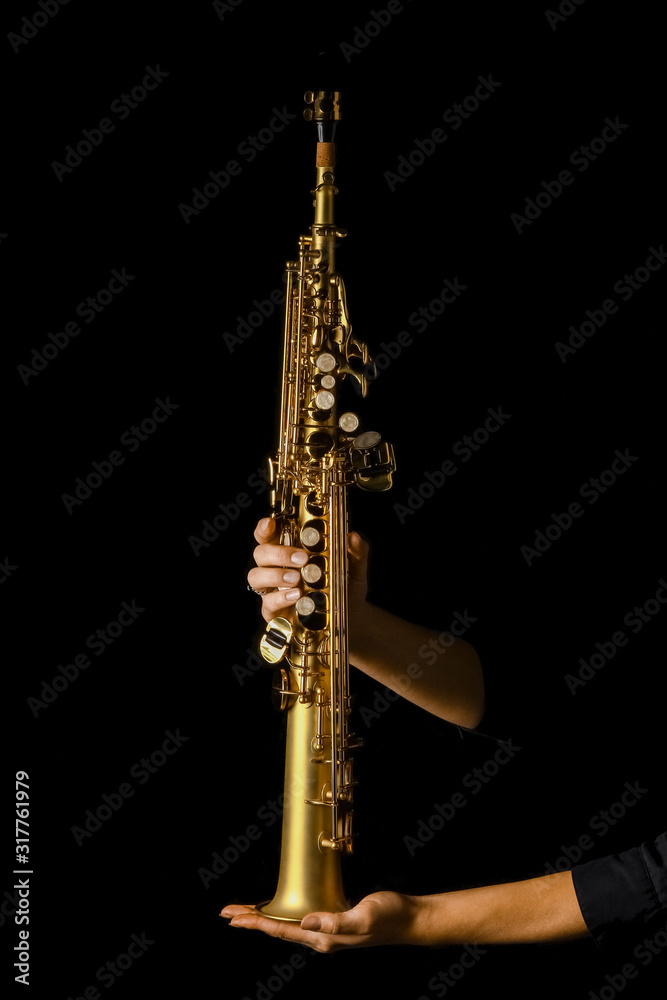 soprano saxophone in hands on a black background soprano saxophone in hands on a black background