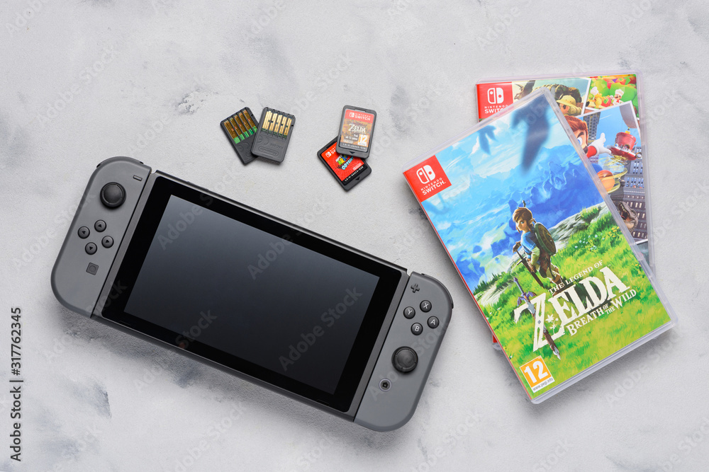 Nintendo Switch gaming console with popular Zelda and Mario games and game  cards flat lay on table. Illustrative editorial. Stock-Foto | Adobe Stock