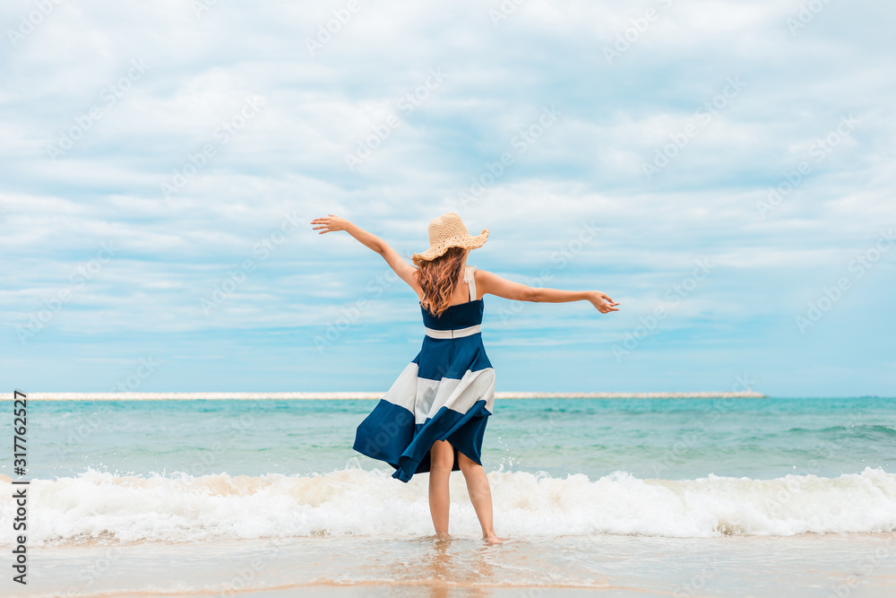 Happy Woman in summer vacation wearing hat and dress enjoying the view at the island beach. Happy Woman in summer vacation wearing hat and dress enjoying the view at the island beach.