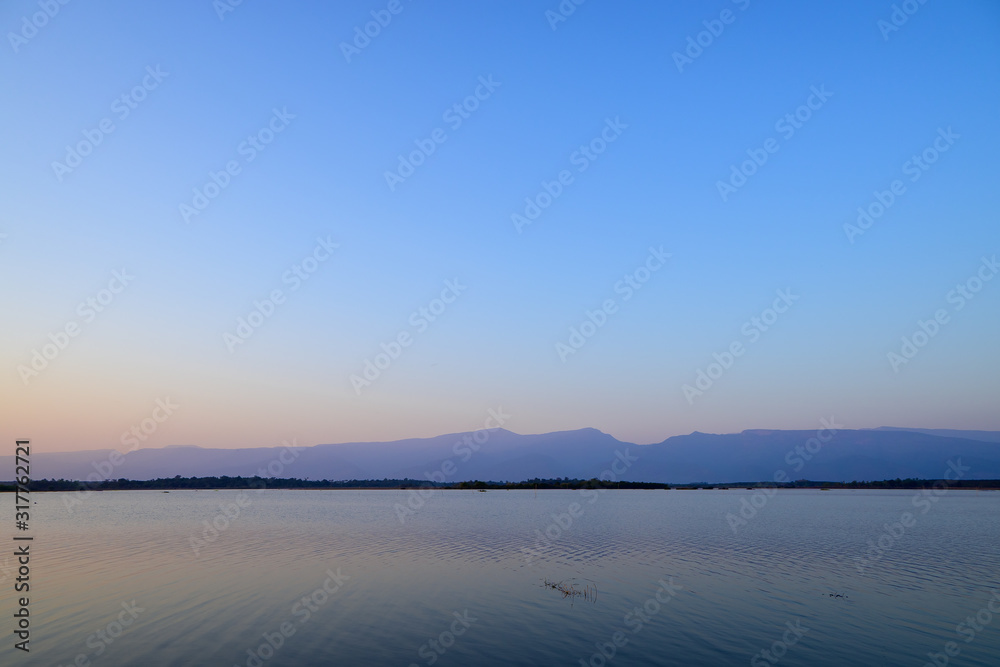 Scenic views of the lak with a mountainous backdrop against blue sky