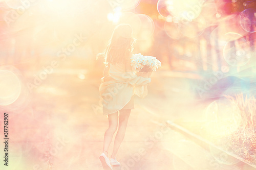 girl holding a bouquet of flowers a walk in the park / romantic young beautiful cute model, love feelings gift