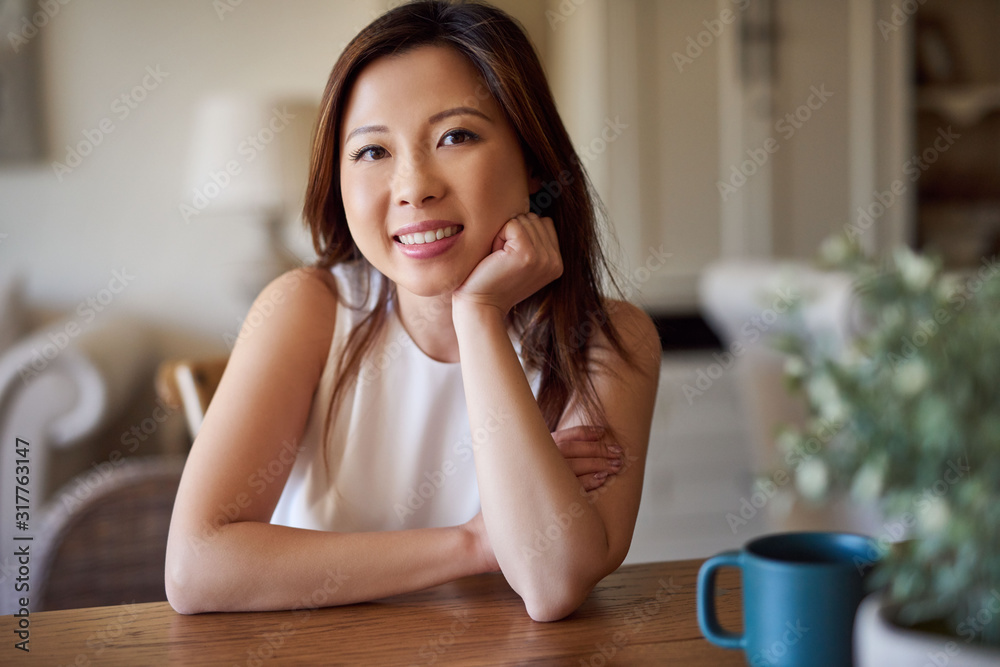 Smiling Asian woman spending a relaxing day at home Smiling Asian woman spending a relaxing day at home