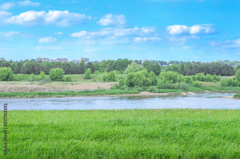 Beautiful summer landscape of empty grass field near river. Landscape on banks of Neris river in Kaunas city, Lithuania. . Beautiful summer landscape of empty grass field near river. Landscape on banks of Neris river in Kaunas city, Lithuania. .