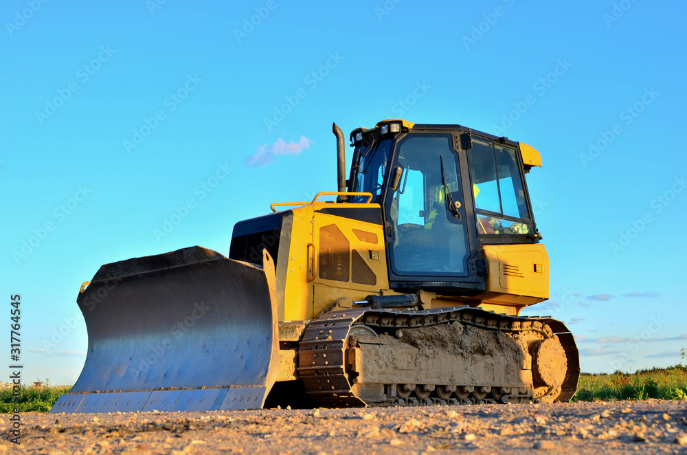 Dozer with buckets at construction site. Bulldozer during land clearing, grading, pool excavation, utility trenching and foundation digging. Possible granularity Dozer with buckets at construction site. Bulldozer during land clearing, grading, pool excavation, utility trenching and foundation digging. Possible granularity