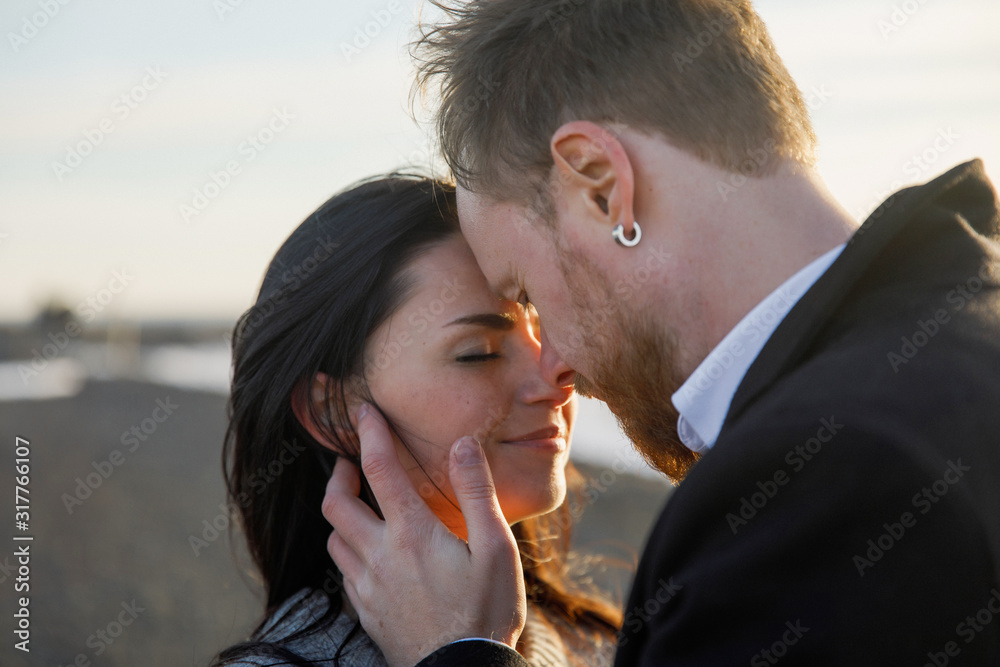 portrait of a young beautiful couple kisses at sunset portrait of a young beautiful couple kisses at sunset