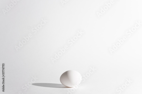 White egg on a white background in the center. Modern easter card. Design, visual art, minimalism © sipcrew