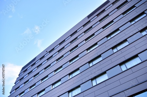 A view at a straight facade of a modern building with a dark grey facade.