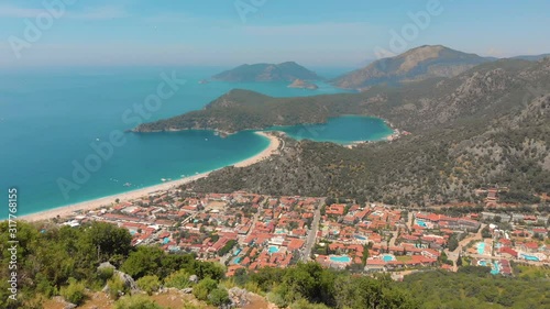 Aerial view of summer city near mountains and sea water. Flying above mountains. Drone shot
