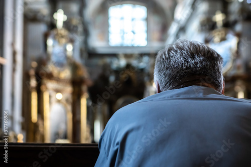 Foto An unidentified man praying in a church.