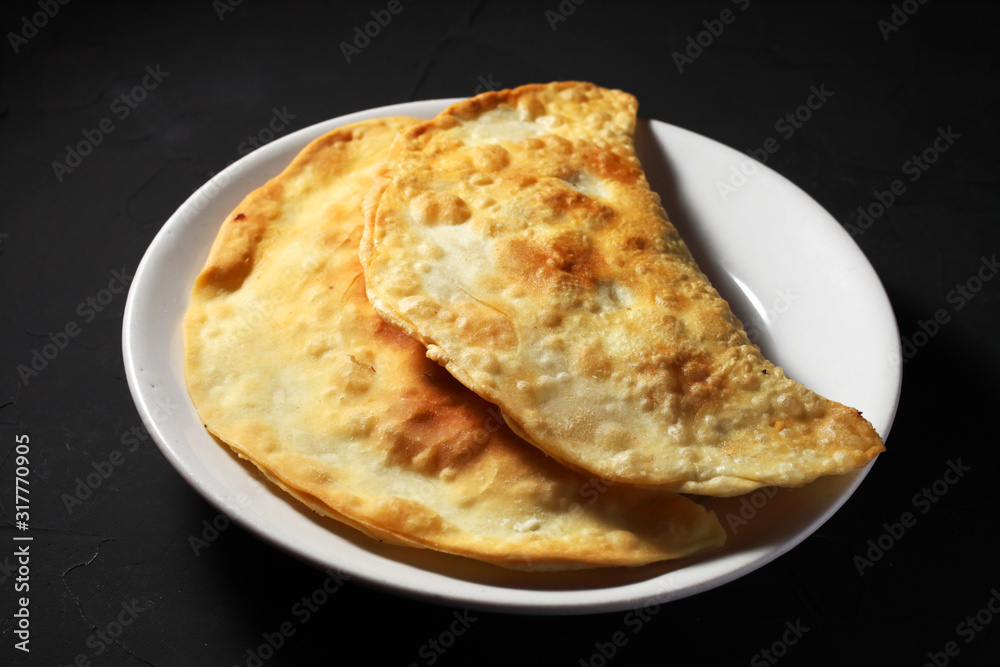 traditional Russian chebureks on a dark background close-up