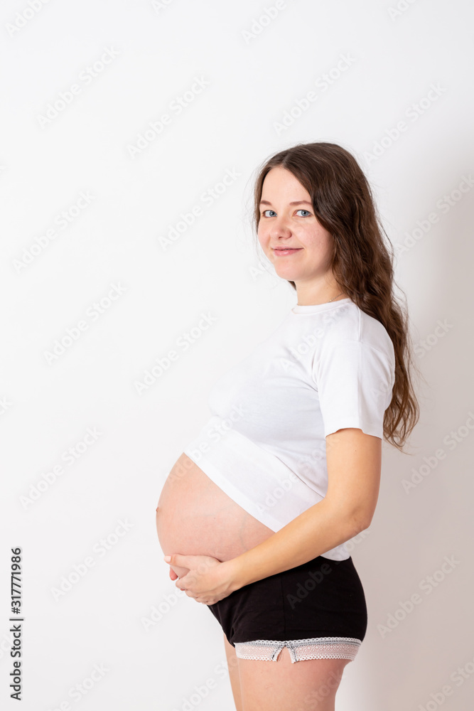 The young beautiful pregnant woman experiences strong emotions on a white background The young beautiful pregnant woman experiences strong emotions on a white background