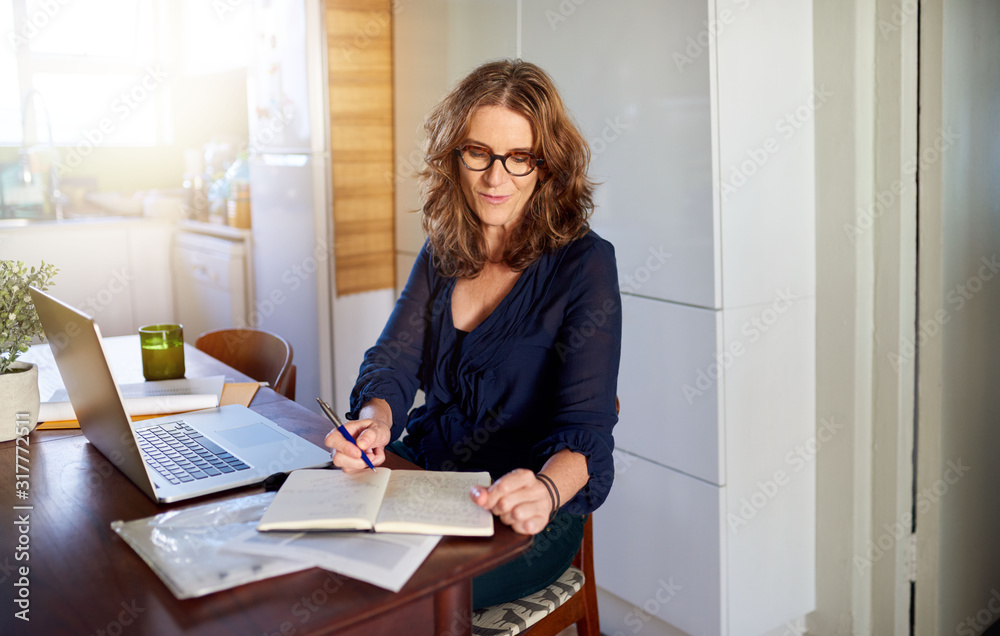 Mature female entrepreneur working at a desk in her office Mature female entrepreneur working at a desk in her office
