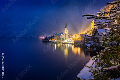 Bick auf das winterliche Hallstatt am Abend mit Schnee und warmer Beleuchtung, Österreich
