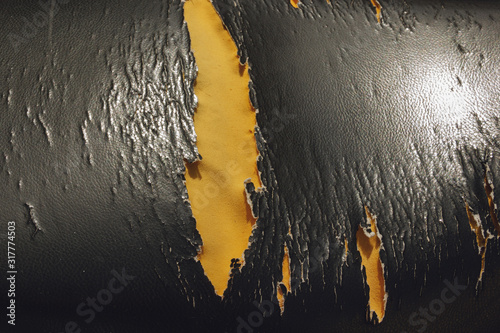 Close up of lack old leather seat .Abstract background of torn old leather sofa. The old motorcycle seat is torn. Motorcycle seat is absent. old and ripped motorbike seat with visible foam..
