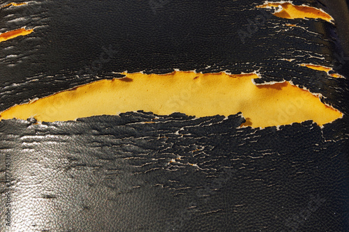 Damaged motorcycle seats background, Motorcycle repairman background. Peeling faux leather couch. A close-up of a damaged black faux leather.torn motorcycle cushion. Lacerated motorcycle seat..