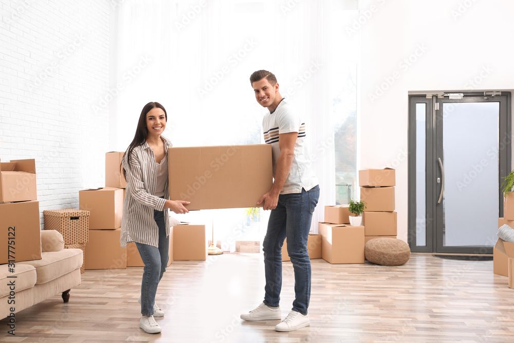Happy couple in room with cardboard boxes on moving day Happy couple in room with cardboard boxes on moving day