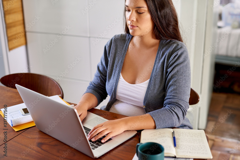 Young preganant woman working online while on maternity leave Young preganant woman working online while on maternity leave