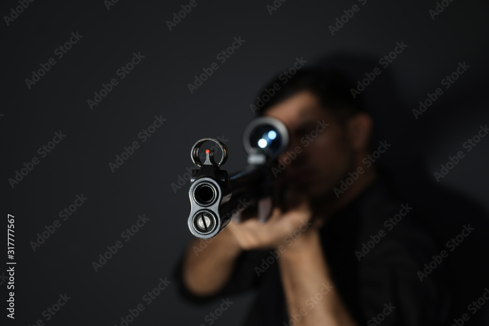 Professional killer on black background, focus on sniper rifle Professional killer on black background, focus on sniper rifle