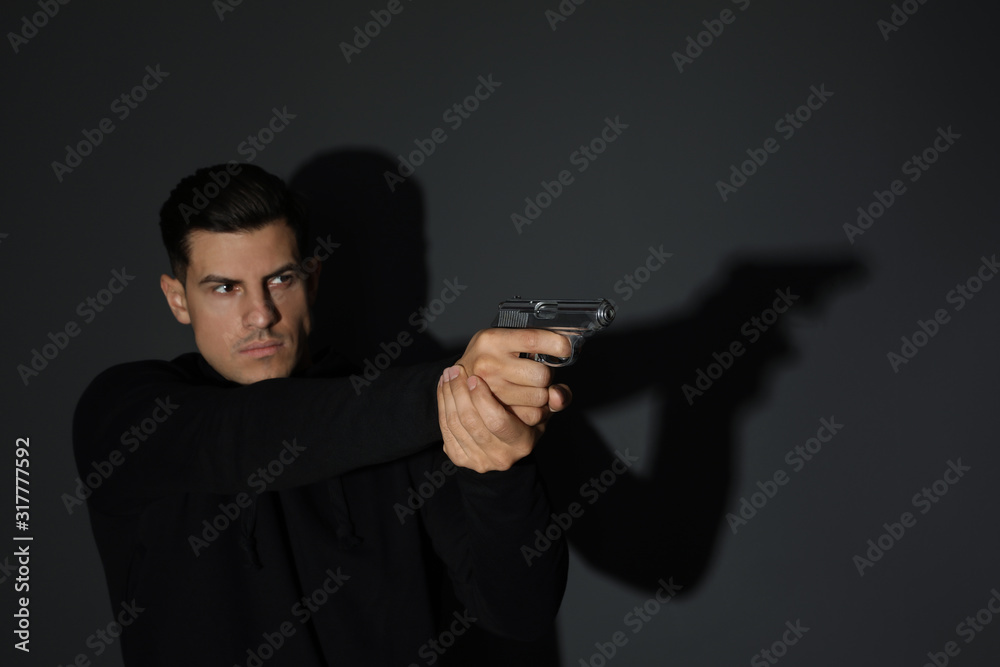 Professional killer with gun on black background Professional killer with gun on black background