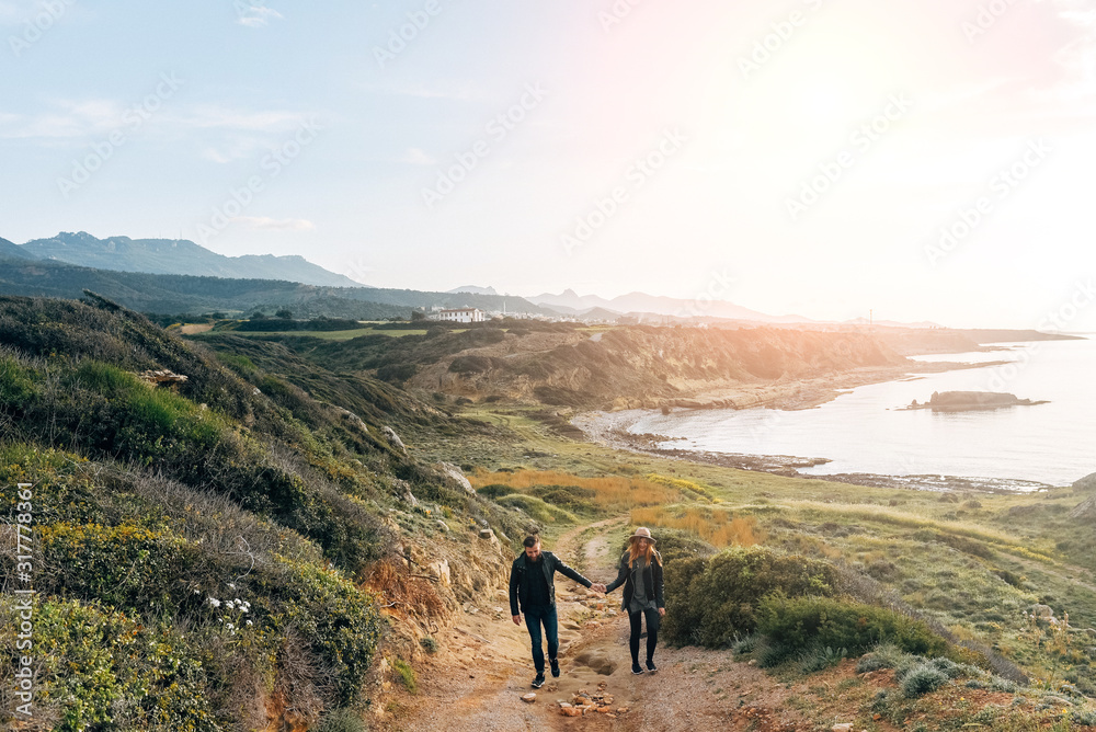 Happy couple running across a field