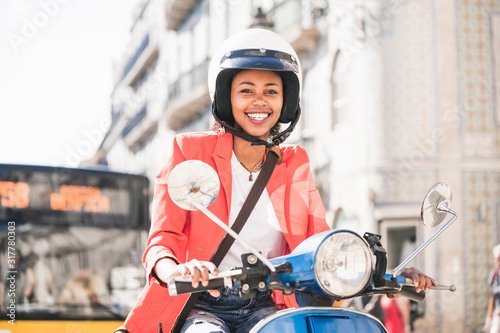 Portrait of happy young woman riding motor scooter in the city, Lisbon, Portugal photo