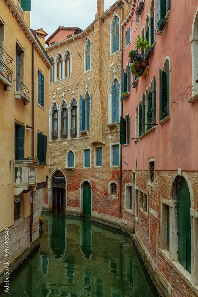 A beautiful photo of the canals of Venice through which gondolas walk and carry tourists
